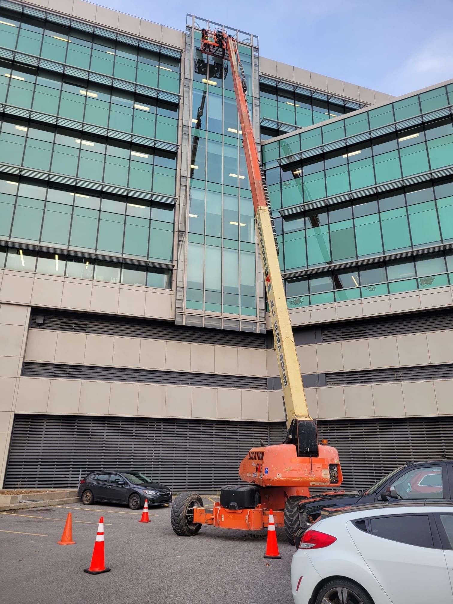 Une grue nettoie les fenêtres d'un grand bâtiment.
