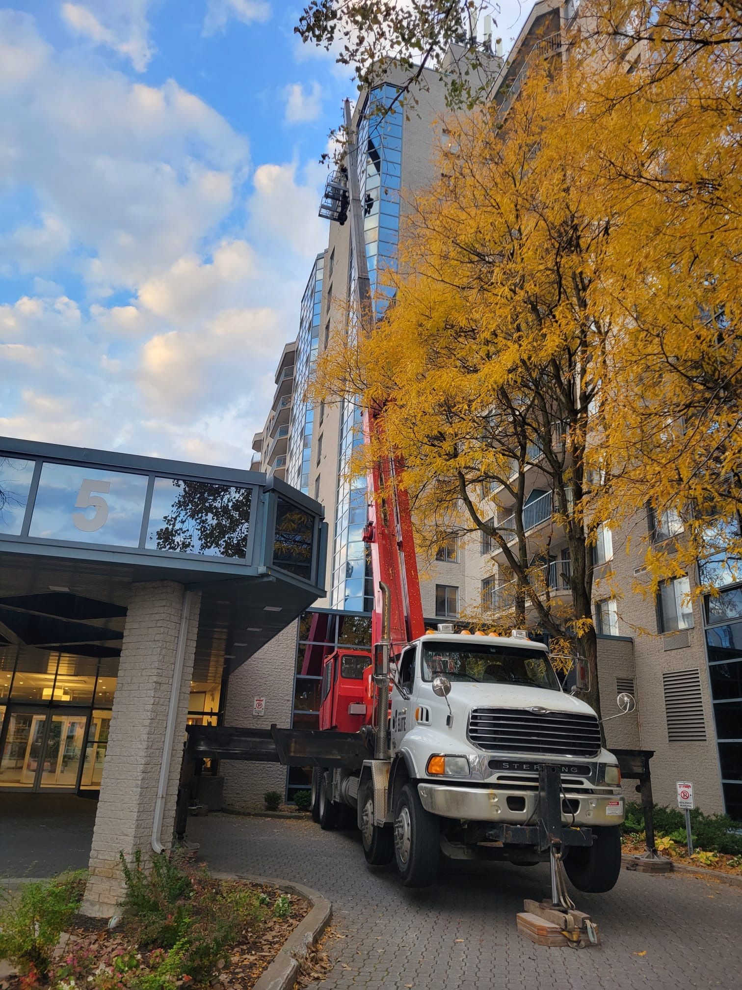 Un camion-grue est garé devant un grand bâtiment.