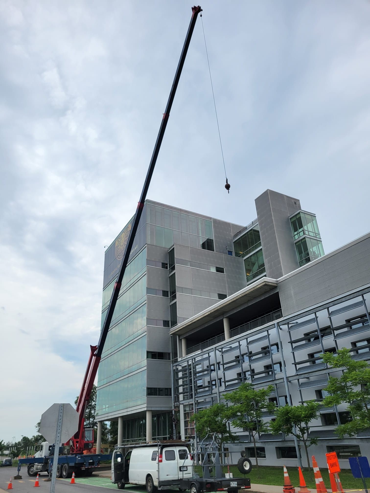 Une grande grue est utilisée pour soulever un grand bâtiment.