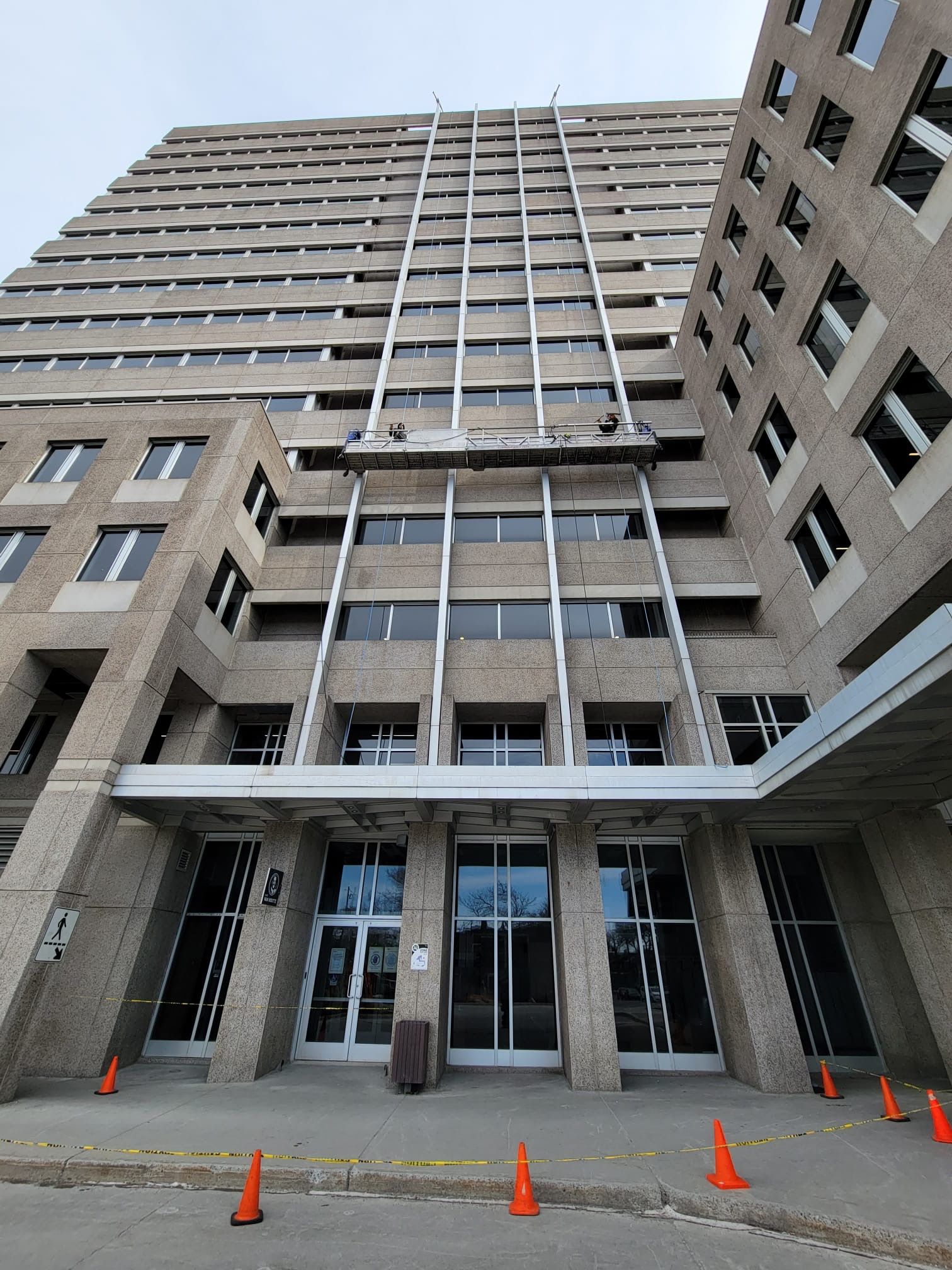 Un grand bâtiment avec beaucoup de fenêtres et de cônes devant lui.