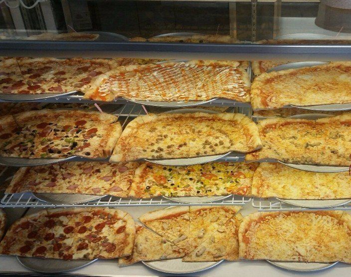 counter full of fresh New York style pizzas