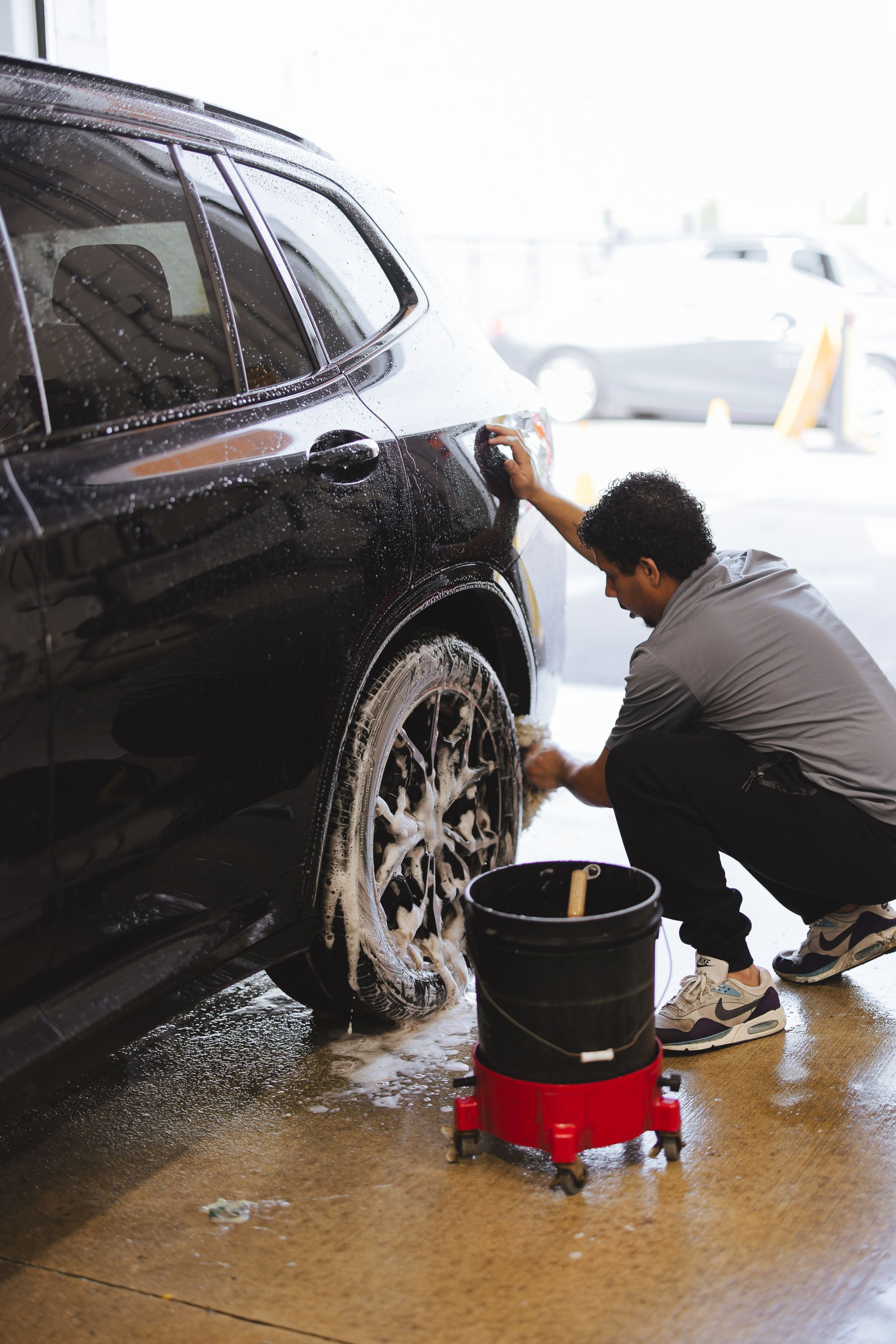 A close up of a blue sports car parked in front of a building.