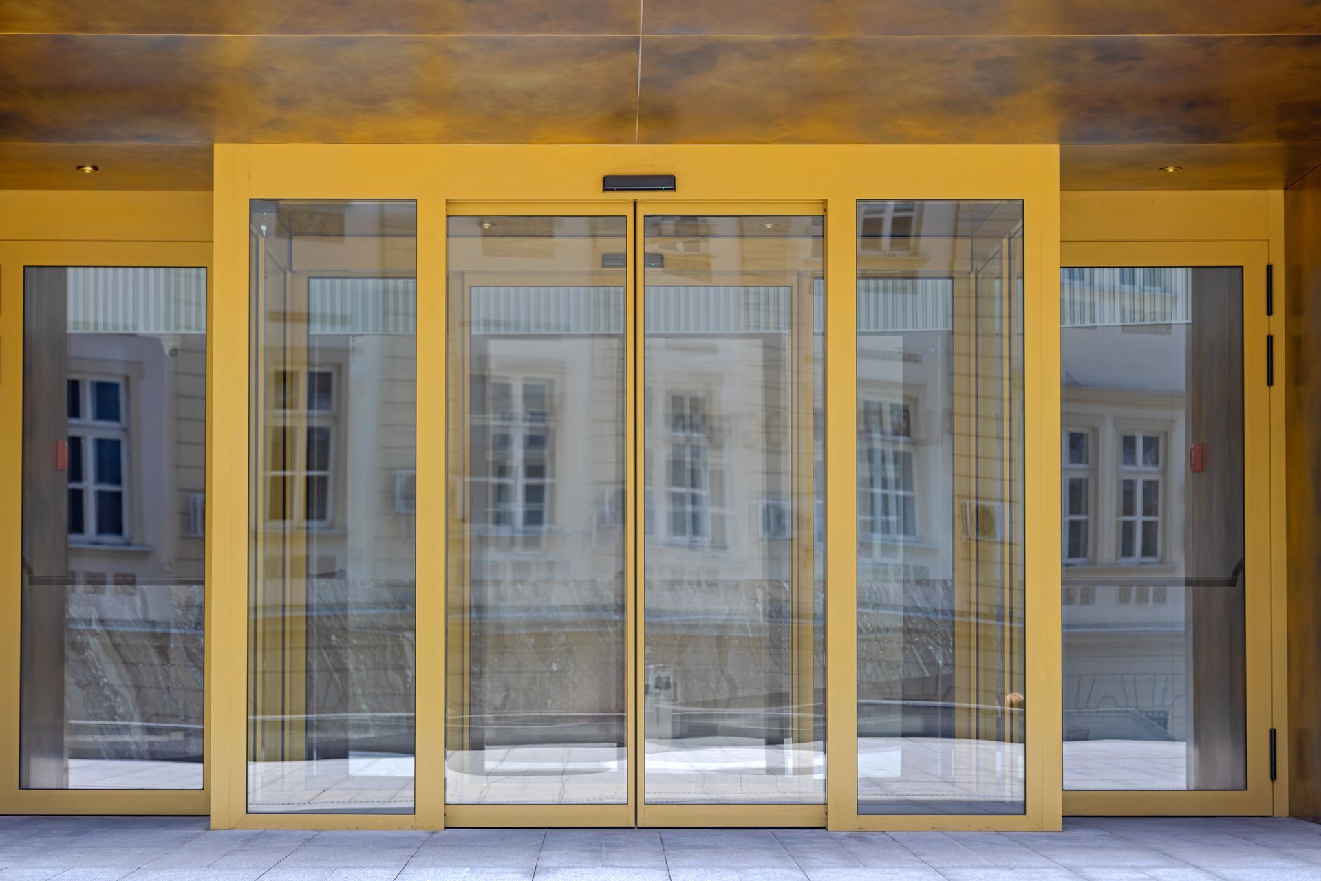 Una grande porta scorrevole in vetro giallo conduce a un edificio.