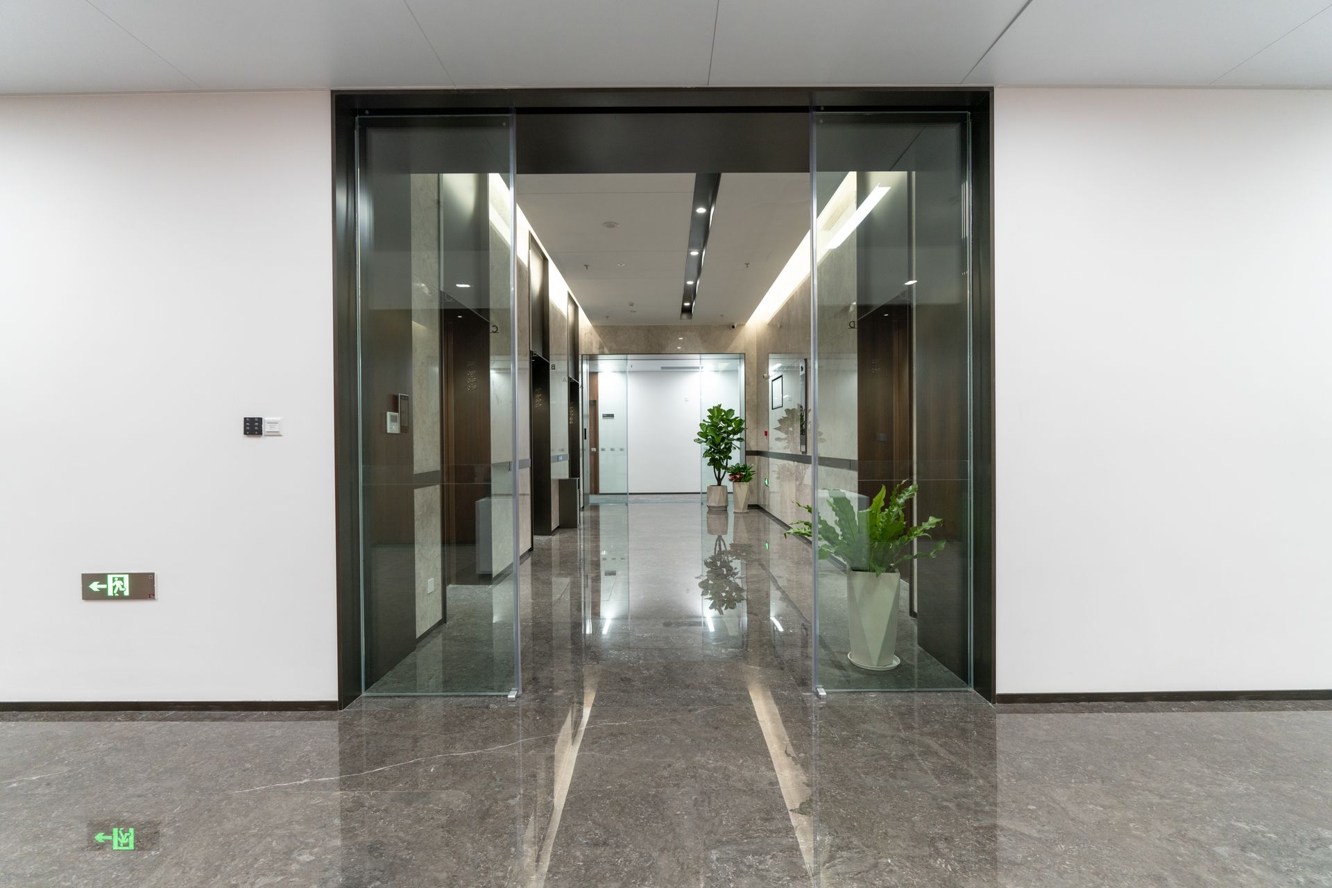 C'è una porta scorrevole in vetro al centro del corridoio.