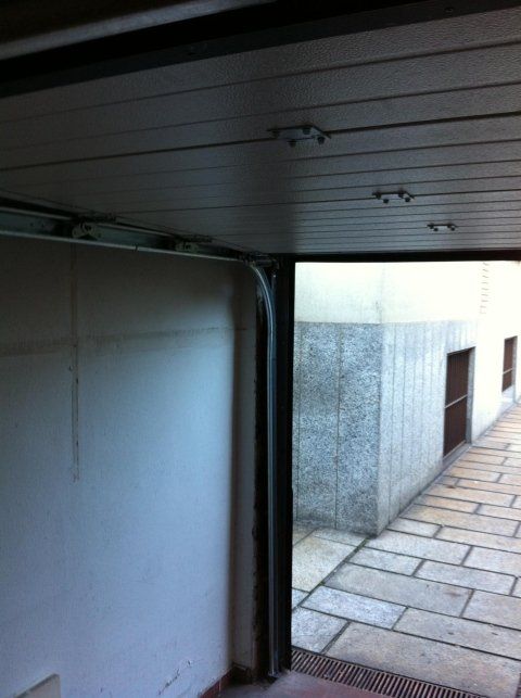 Una porta del garage è aperta su un passaggio pedonale in pietra