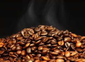 一堆烤好的咖啡豆,冒著熱氣,背景是黑色。