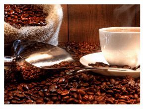 咖啡豆環繞著一杯白咖啡和一把湯匙；背景中可以看到一個粗麻布袋。