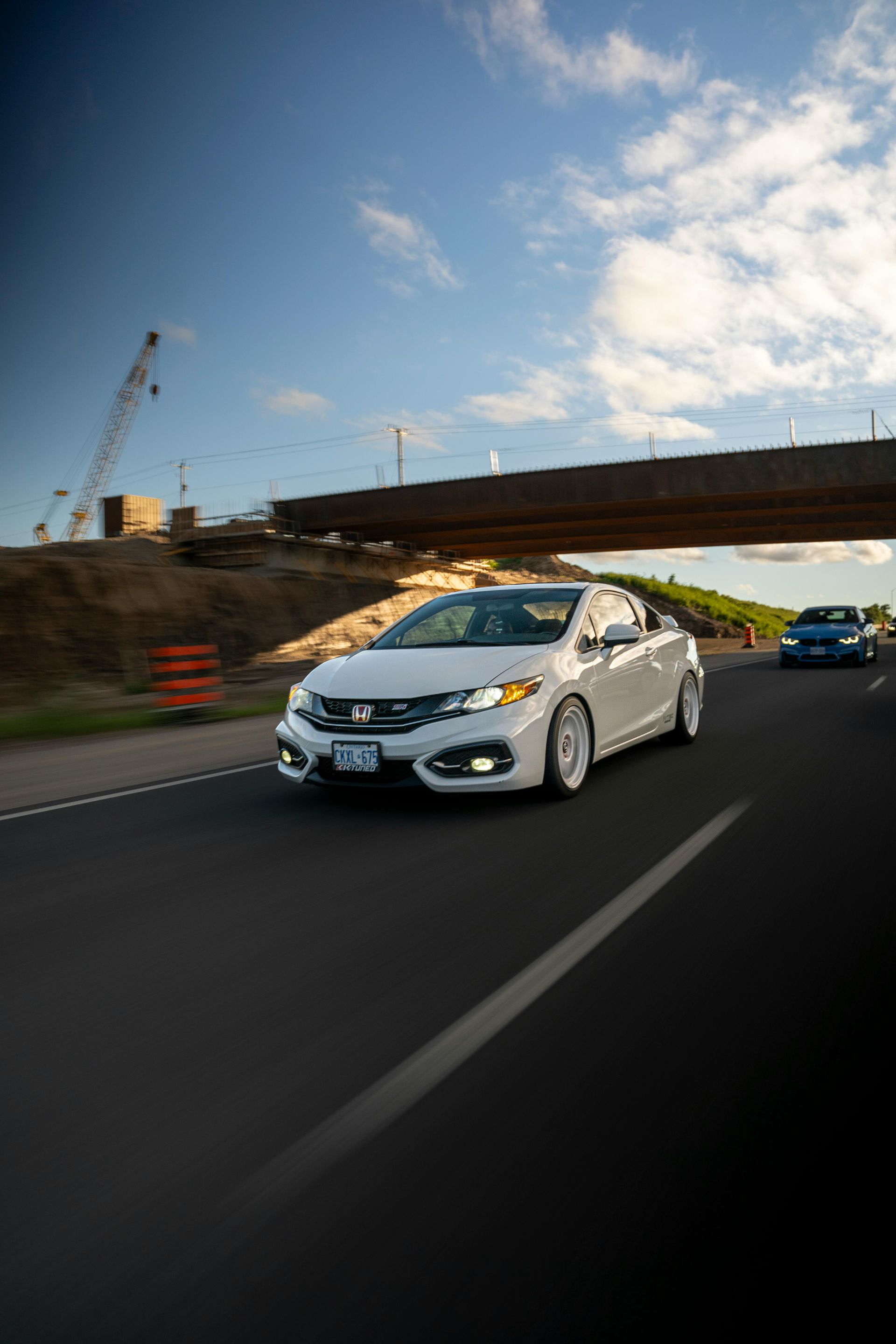 Silver Toyota 4Runner front-end close-up on a winding road, fog light on, daytime.