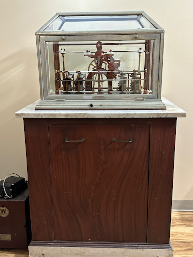 an antique clock is sitting on top of a wooden cabinet .