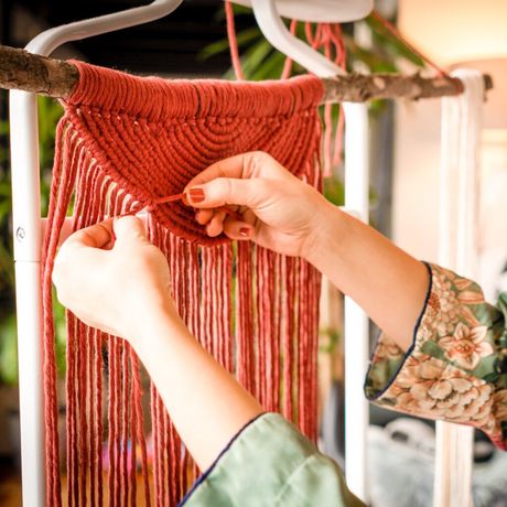 A woman making a macramé art piece