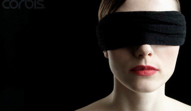 a woman with a blind fold over her eyes.