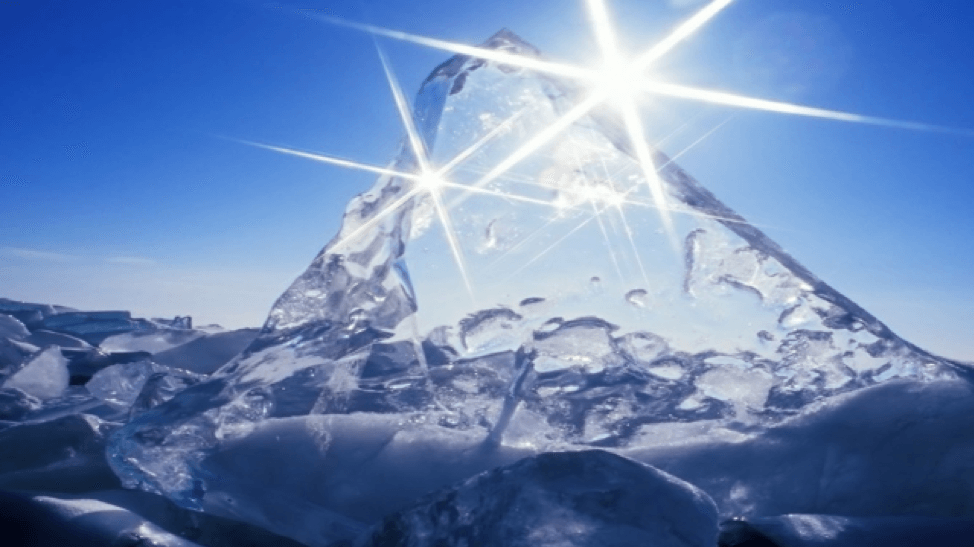 the sun shines brightly over a crystal clear ice berg