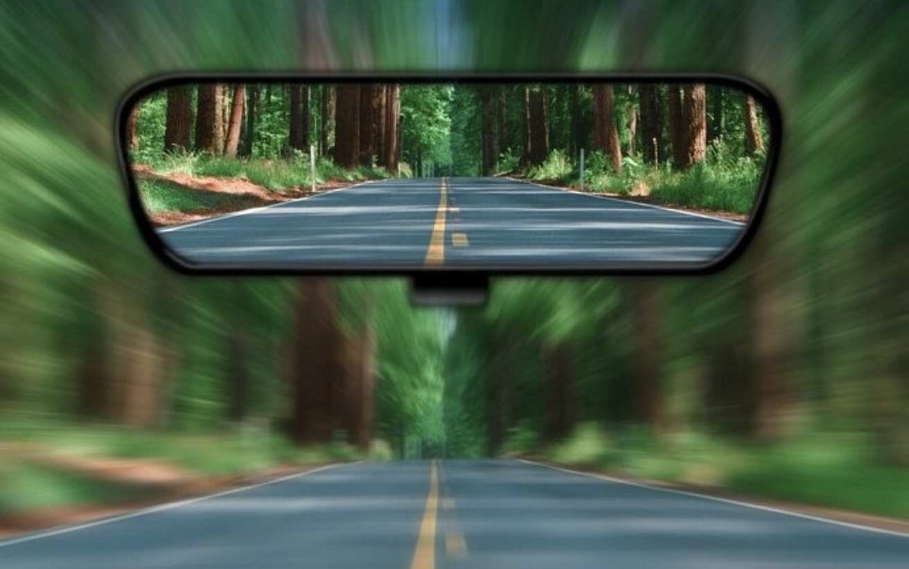 a view of a road through a rear view mirror