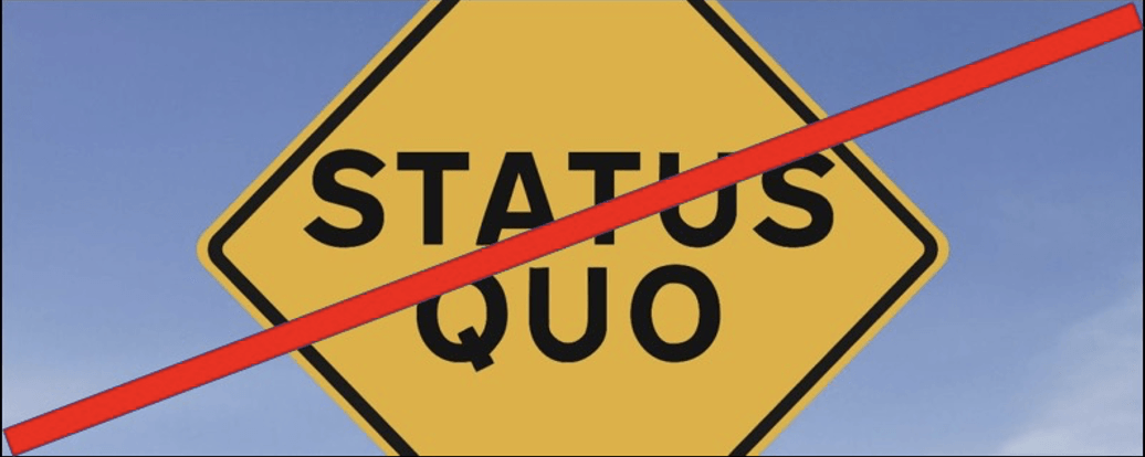 a yellow street sign with the words status quo on it with a a red line in front of a blue sky.