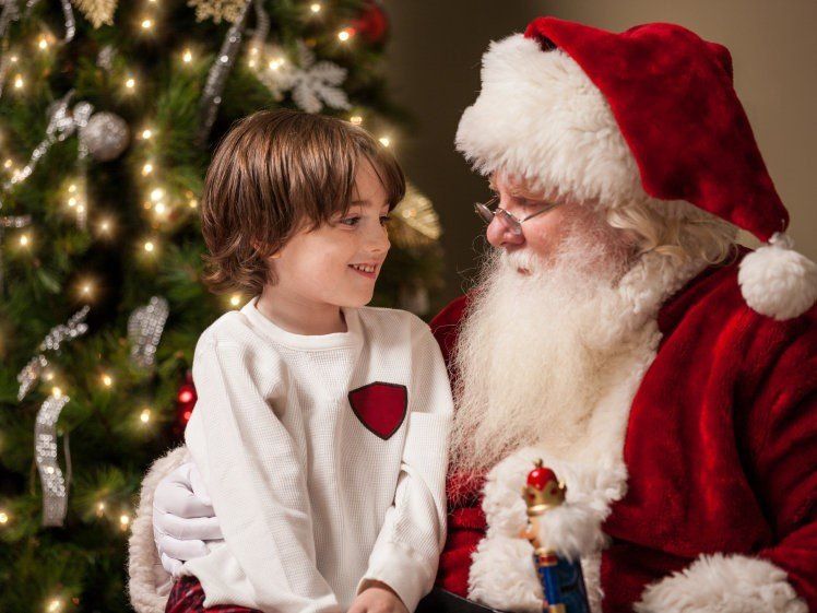 a little boy sitting on Santa clauses lap