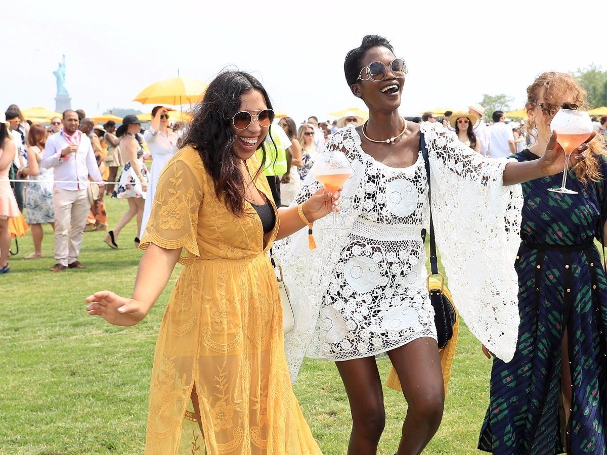 a group of women standing on top of a lush green field living their ideal life