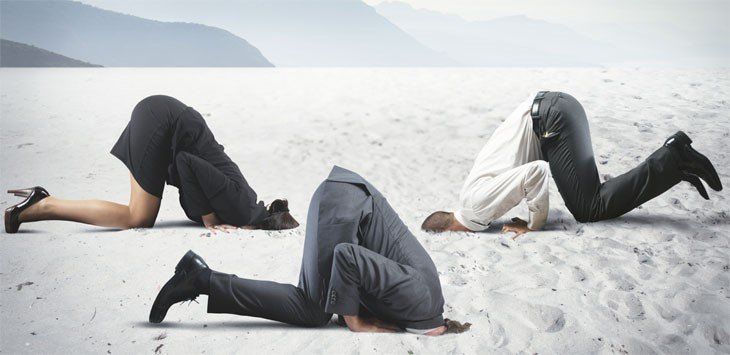 A group of business people with their heads in the sand