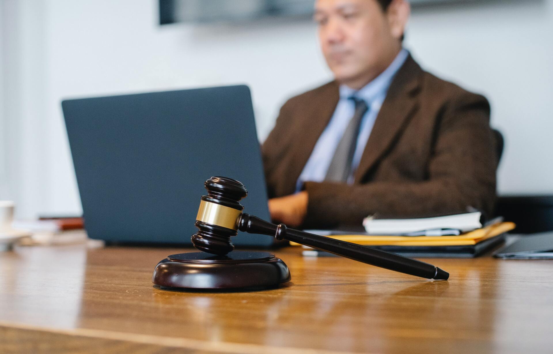 a judge sitting at a desk with a laptop