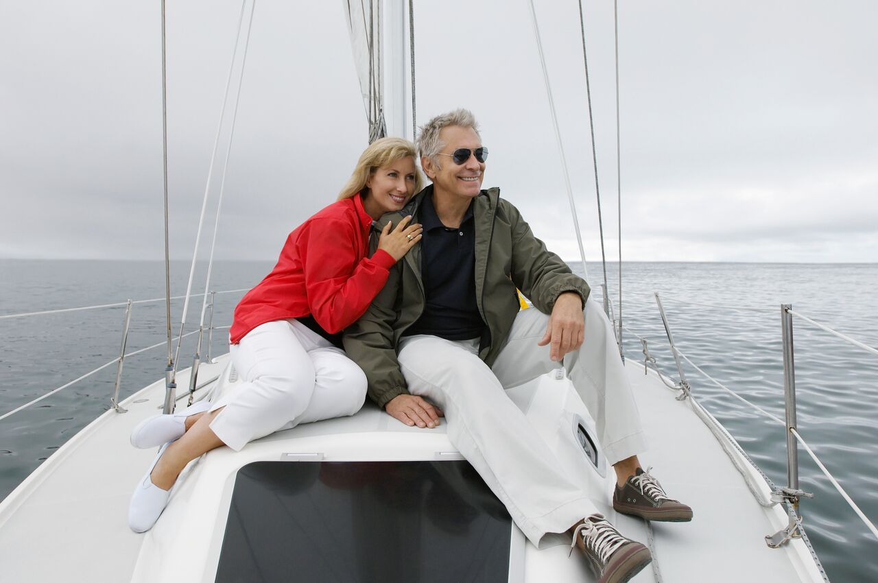 Retired Couple Sitting on Sail Boat On a Cloudy Day Living the Ideal Life