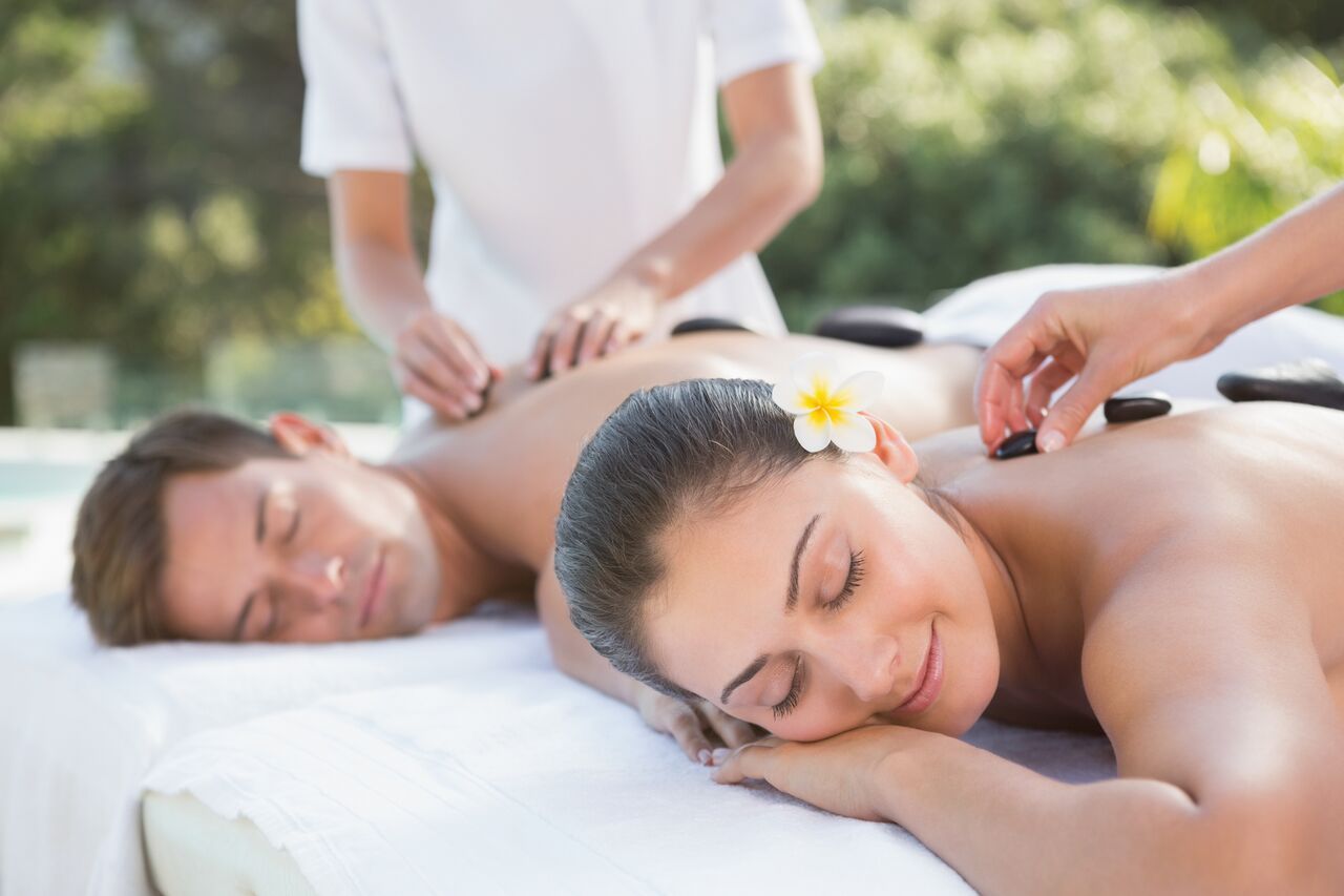 Couple living their ideal life getting a couple massage outside on vacation