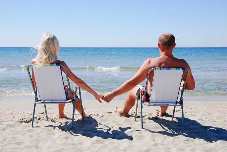 Couple living their ideal life relaxing on the beach looking out onto the ocean