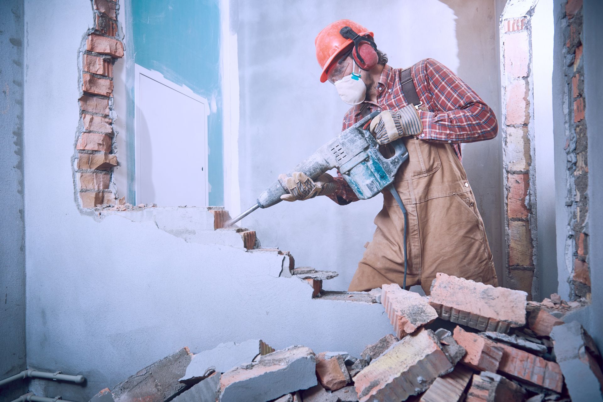 A man is using a hammer to demolish a wall.