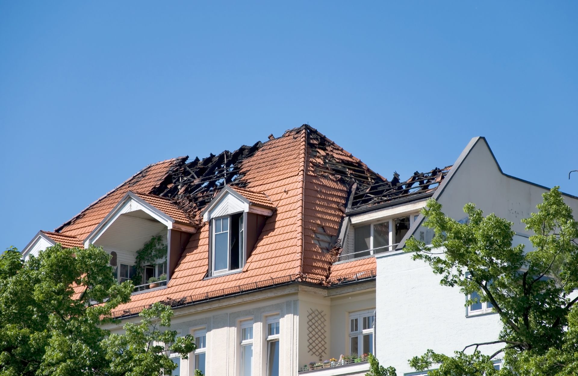 A house with a roof that has been damaged by fire.