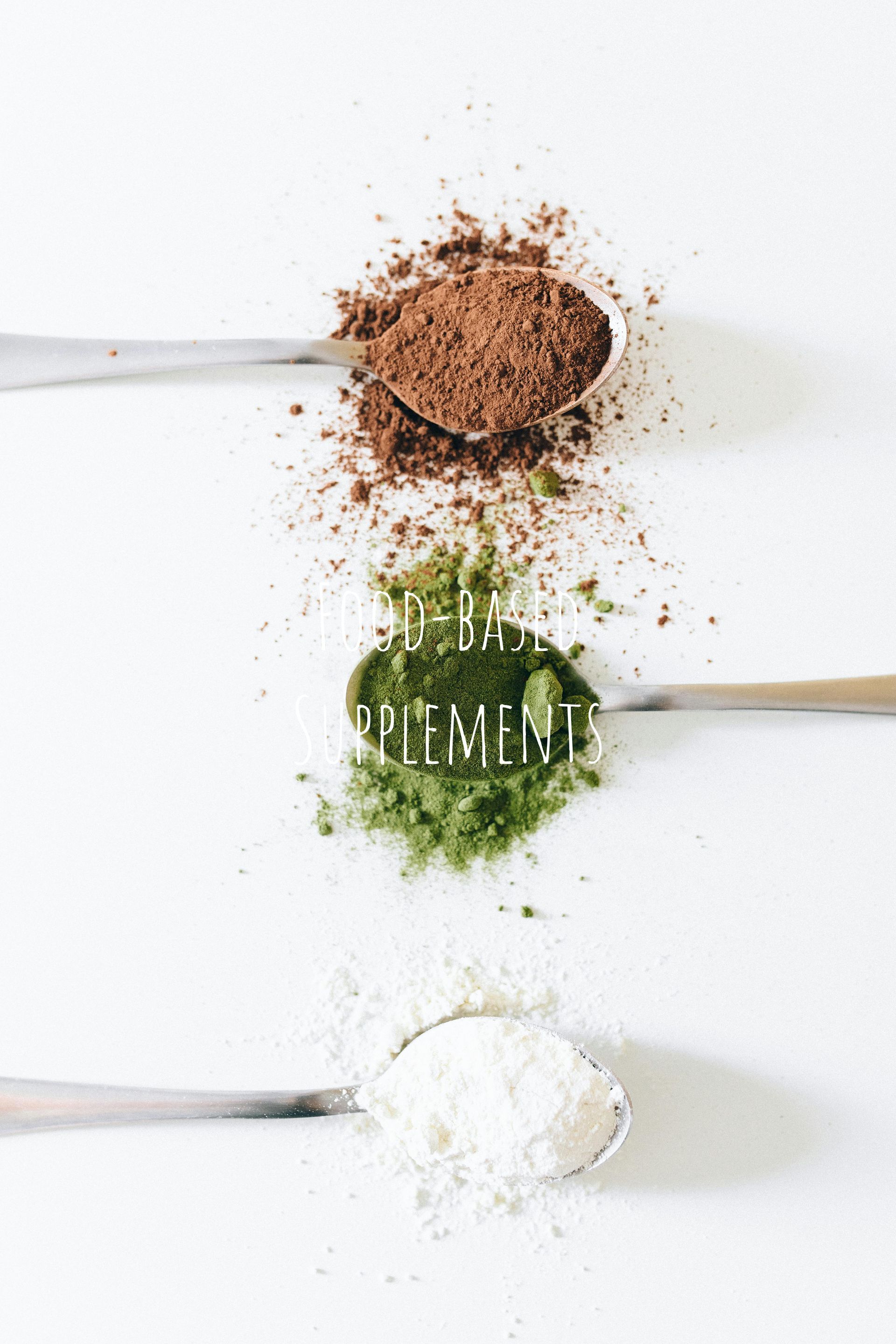Spoons with cocoa, green powder, and white powder, aligned vertically on a white surface. Text: