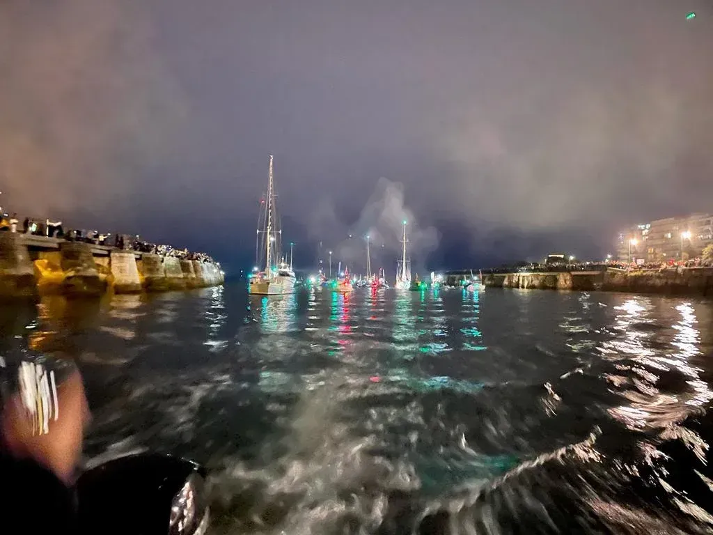 A boat is in the water at night with boats in the background