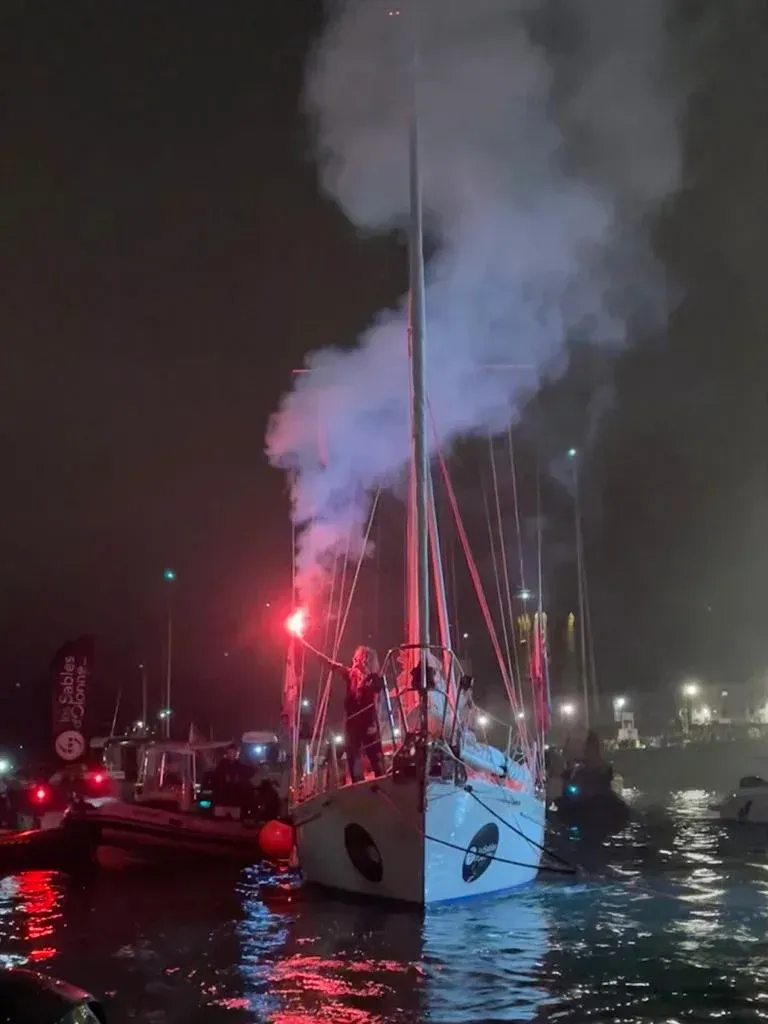 A boat with smoke coming out of the sails at night