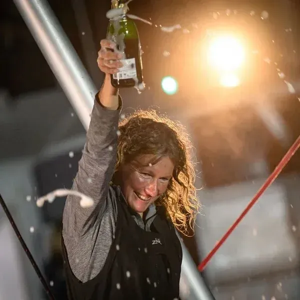 A woman is holding a bottle of champagne in her hand.