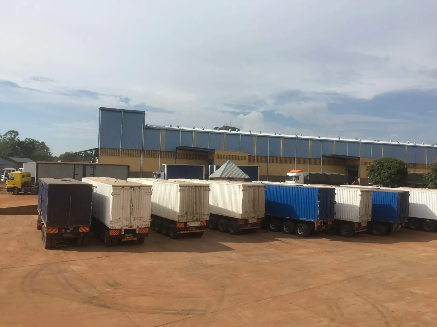 A row of trucks are parked in front of a building.
