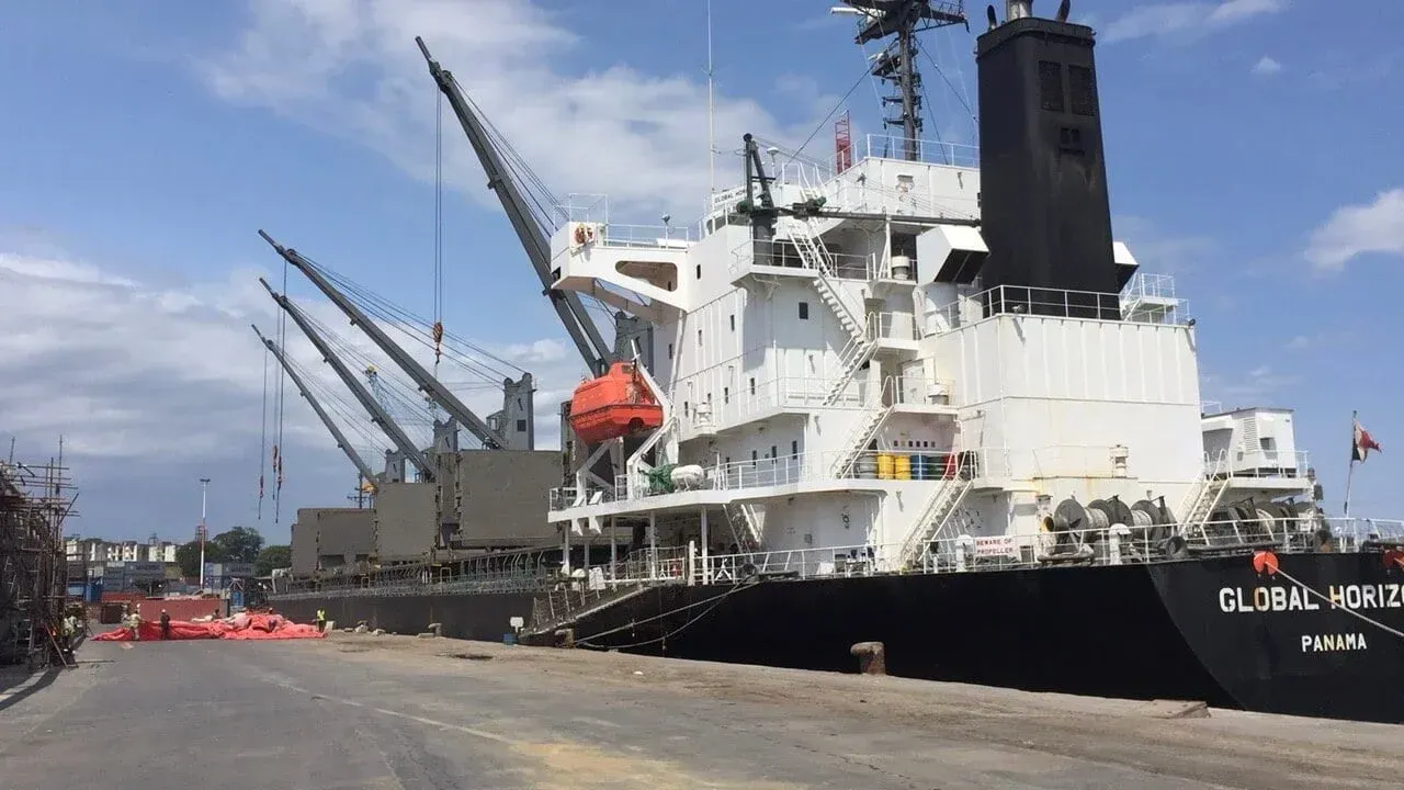 A large cargo ship is docked in a harbor.