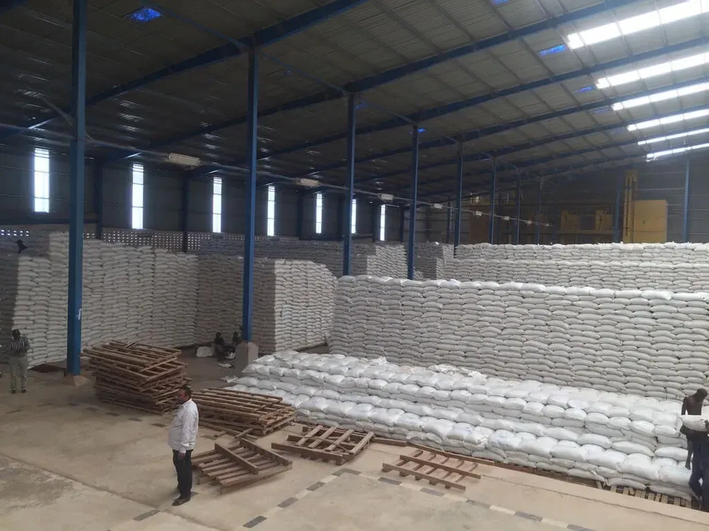 A large warehouse filled with lots of bags and pallets.