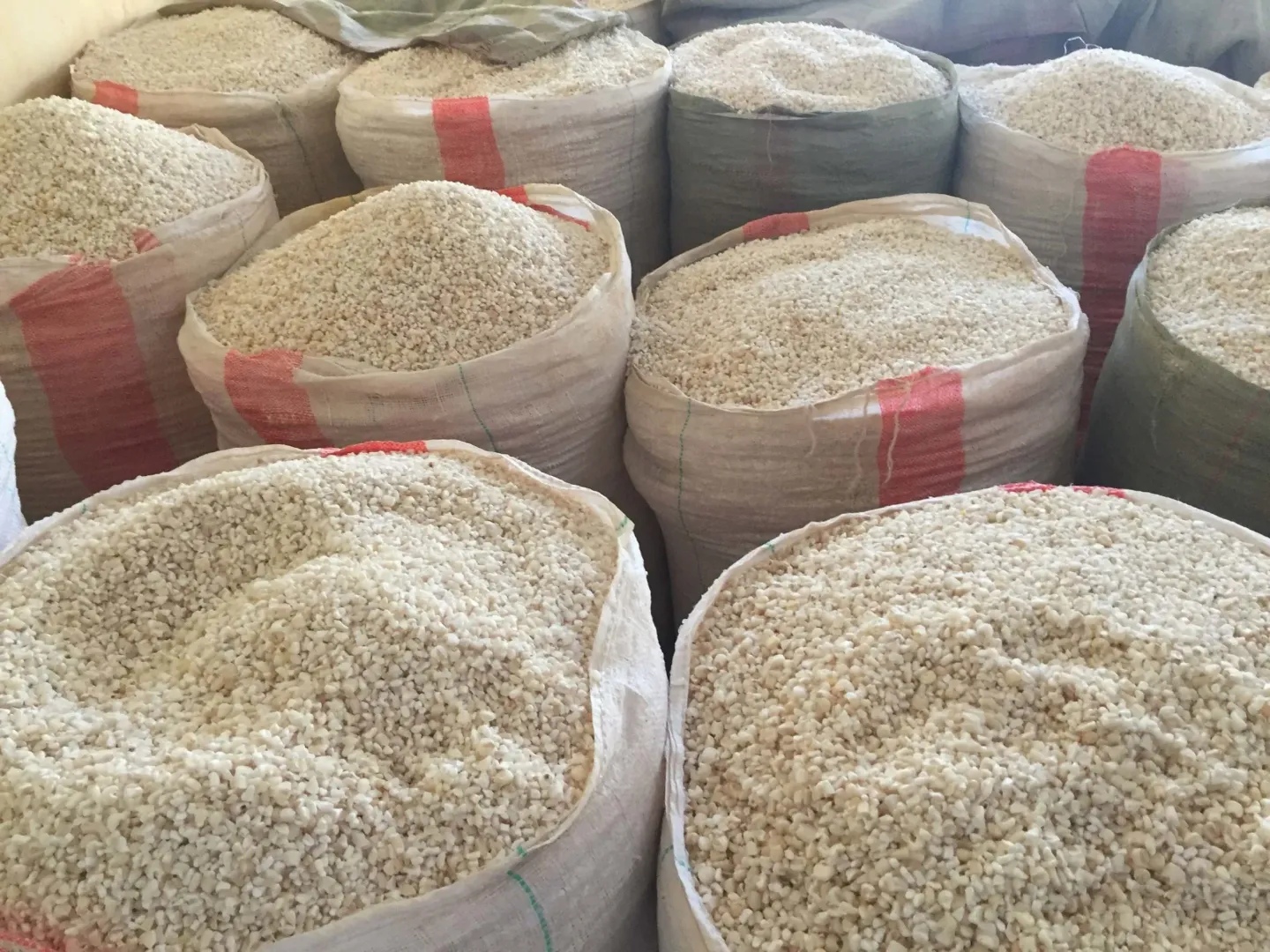 A bunch of bags of rice are stacked on top of each other.