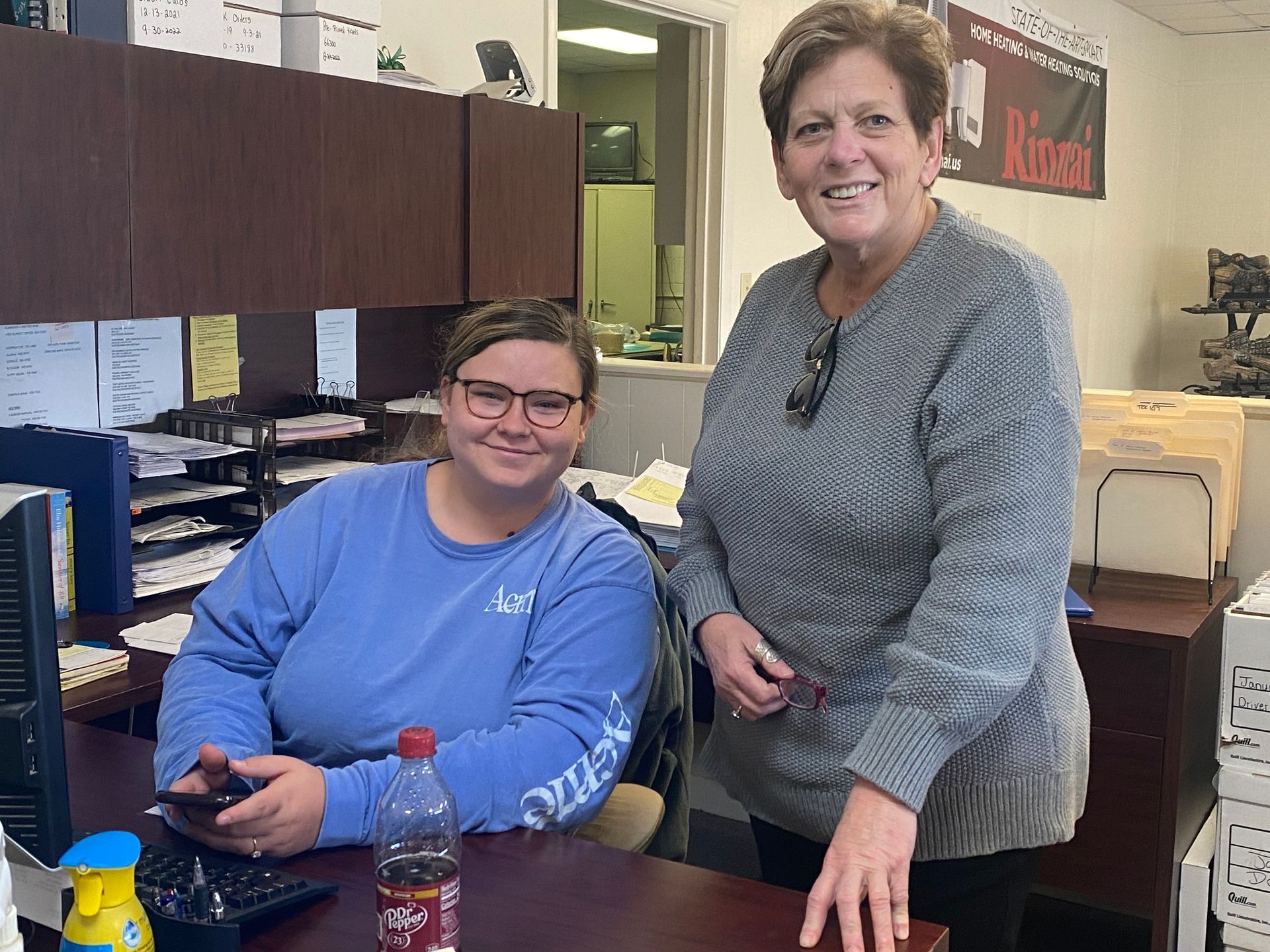 Two women are standing next to each other in an office.