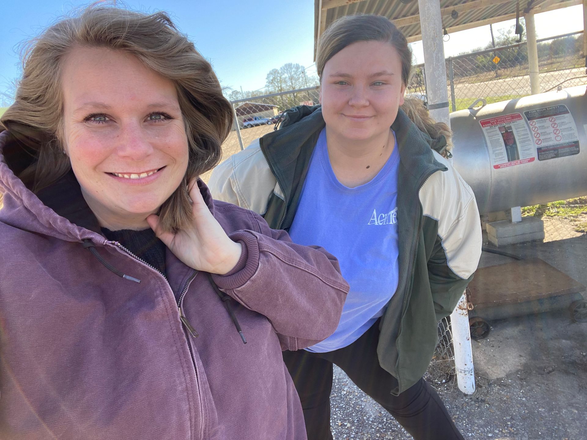 Two women are standing next to each other and smiling for a picture.