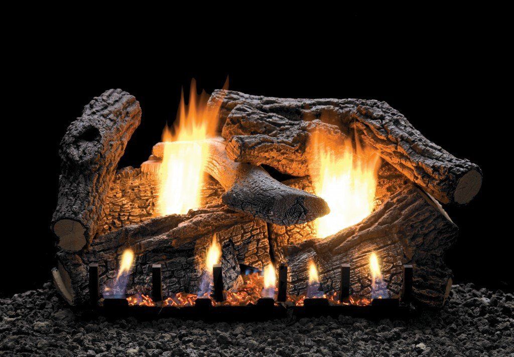 A fireplace made of logs is sitting on top of a pile of gravel.