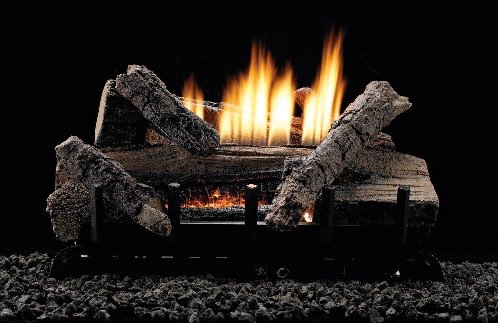 Burning gas fireplace logs with flames against a dark background.