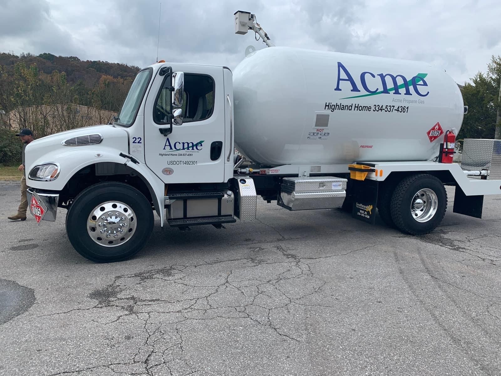 A white truck with the word acme on the side is parked in a parking lot.