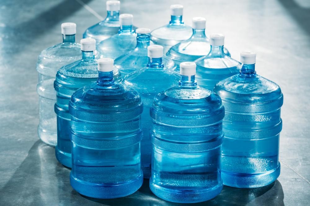 A Bunch of Water Bottles Are Stacked on Top of Each Other on A Table — Cool Blue Ice & Water in Taminda, NSW