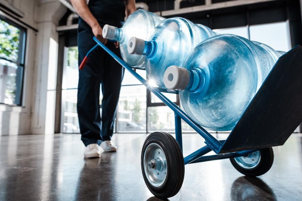 A Man Is Pushing a Cart Filled with Water Bottles — Cool Blue Ice & Water in Lightning Ridge, NSW