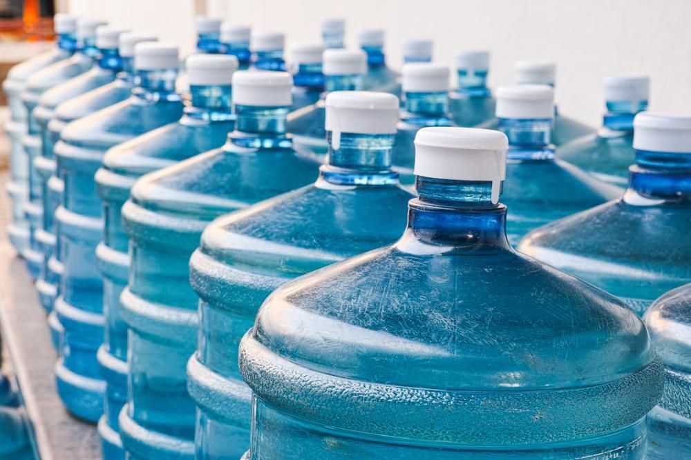 A Row of Water Bottles Sitting on Top of Each Other on A Table — Cool Blue Ice & Water in Moree, NSW