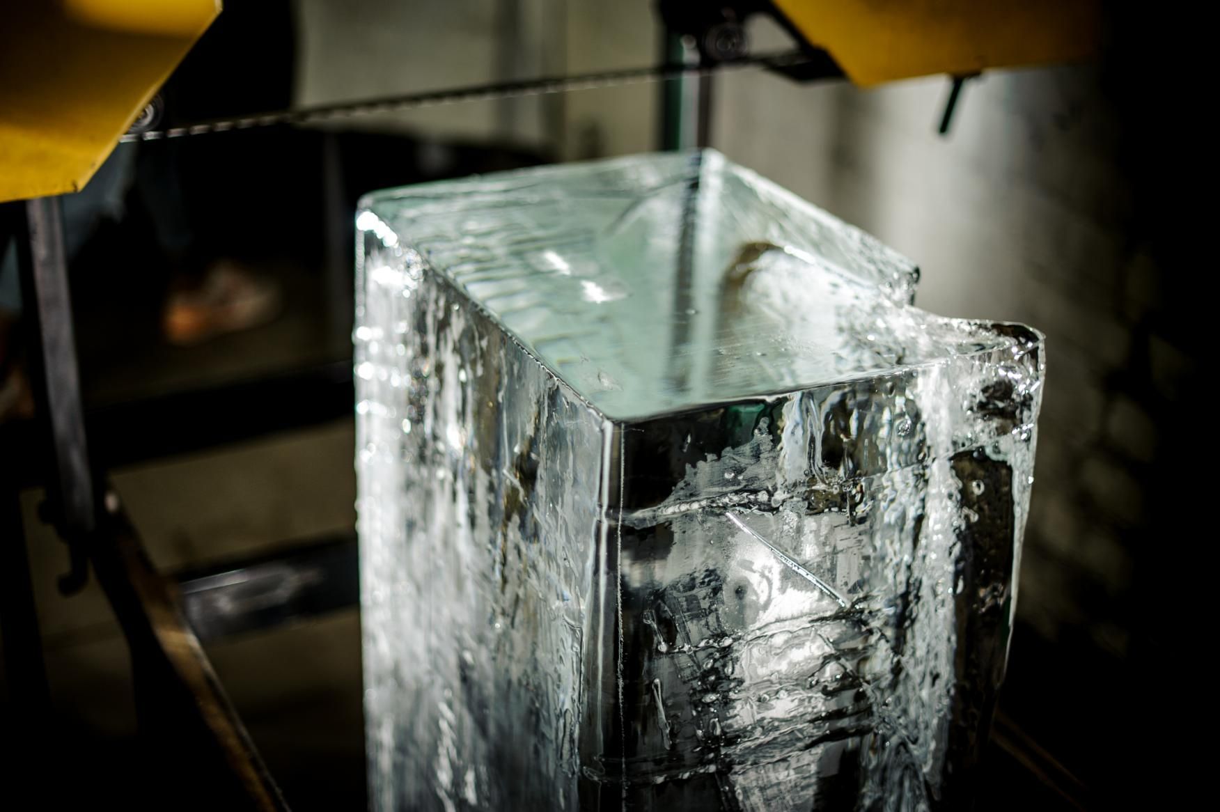 A Large Piece of Ice Is Being Cut with A Saw — Cool Blue Ice & Water in Narrabri, NSW