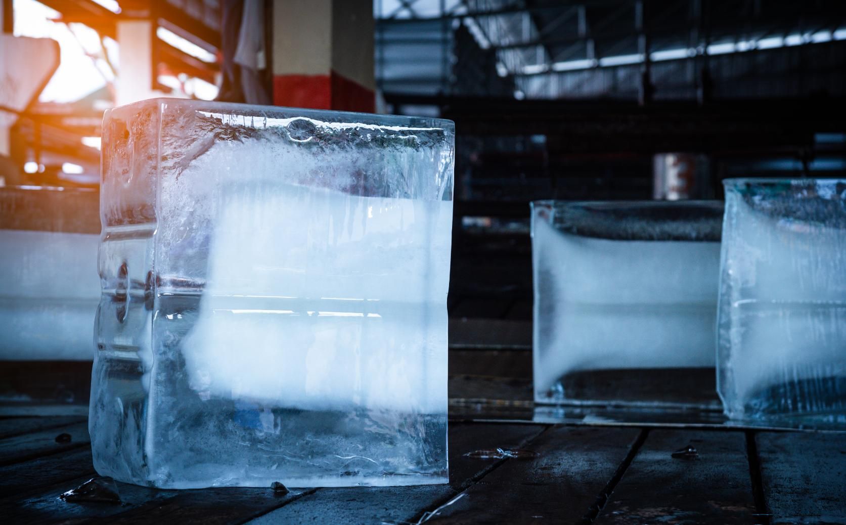 Three Ice Cubes Are Sitting on A Wooden Table — Cool Blue Ice & Water in Dubbo, NSW