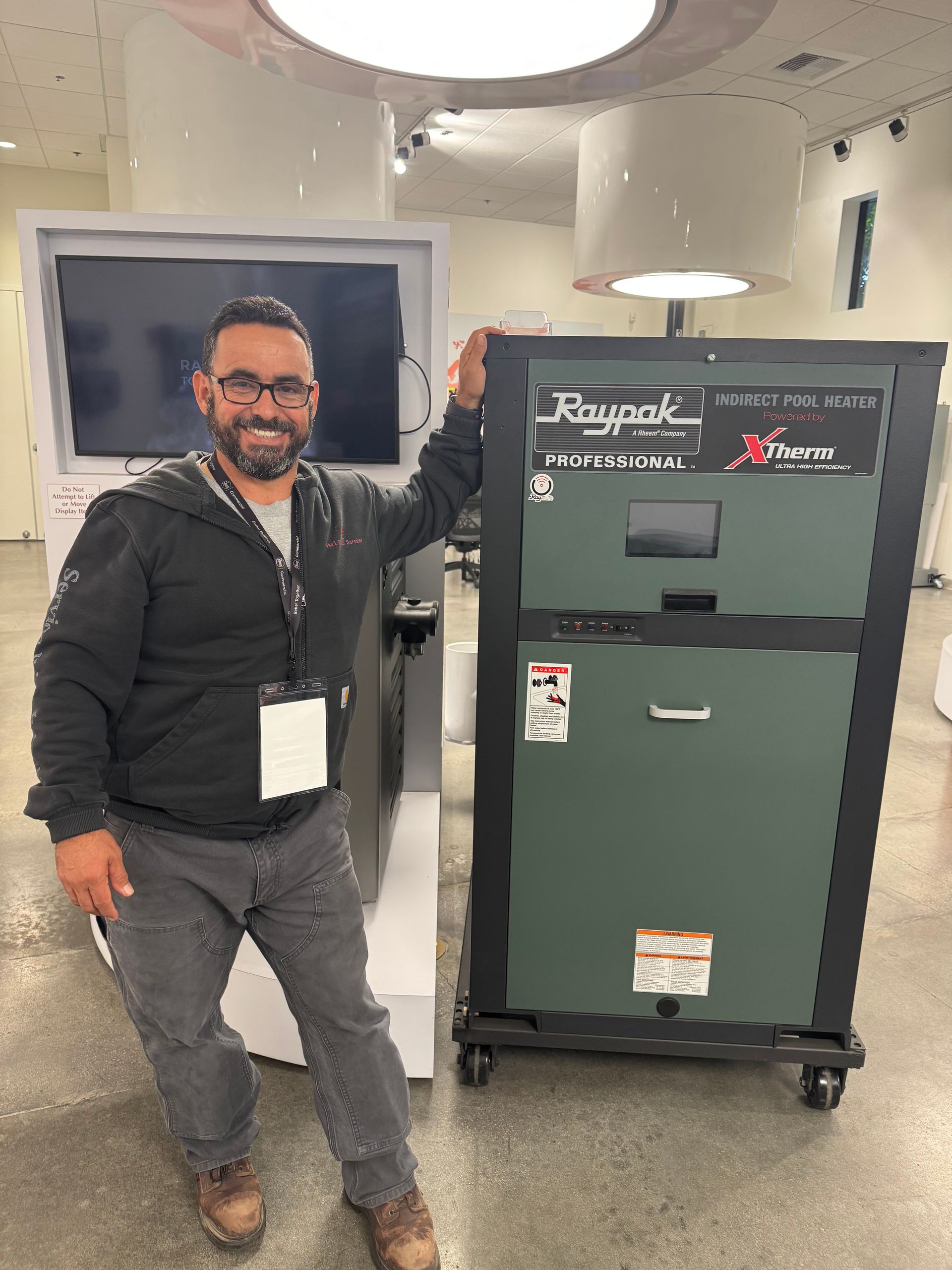 Man in a hard hat and harness working on metal ductwork.