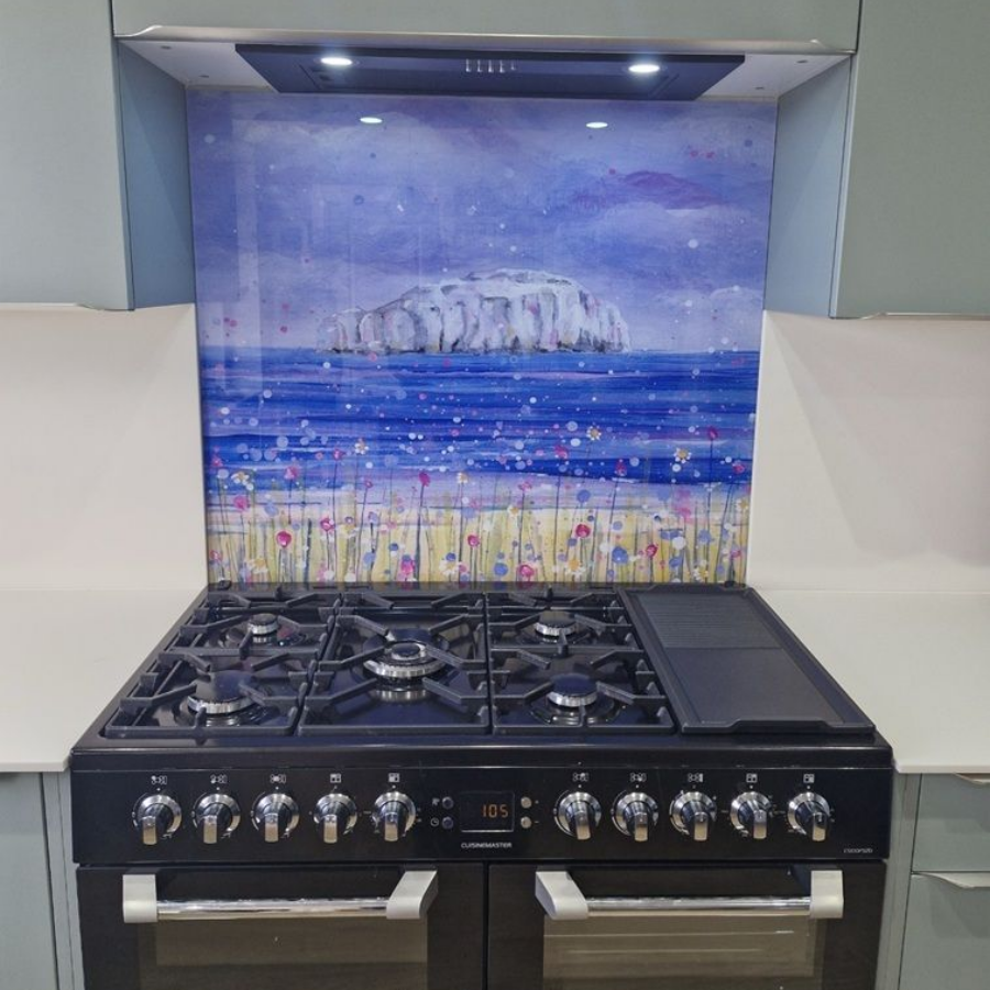 Kitchen stove with custom backsplash depicting Bass Rock beneath a range hood with lights.
