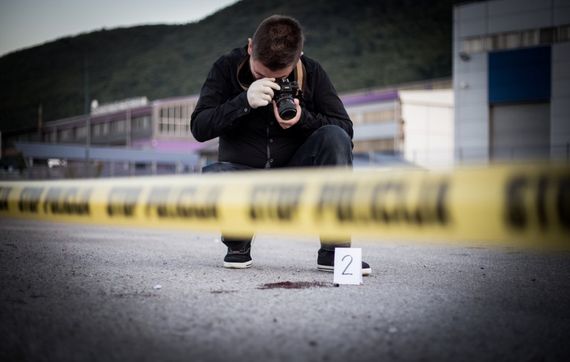 man taking photographs of crime scene