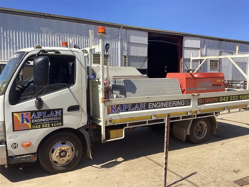 White Flatbed Work Truck Parked Outside a Metal Warehouse — Kaplan Engineering Pty Ltd In Bowen, QLD