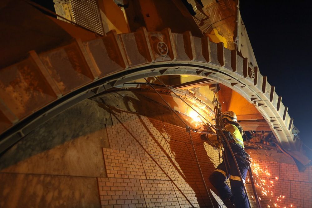 A Man Is Welding A Bridge At Night — Kaplan Engineering Pty Ltd In Bowen, QLD
